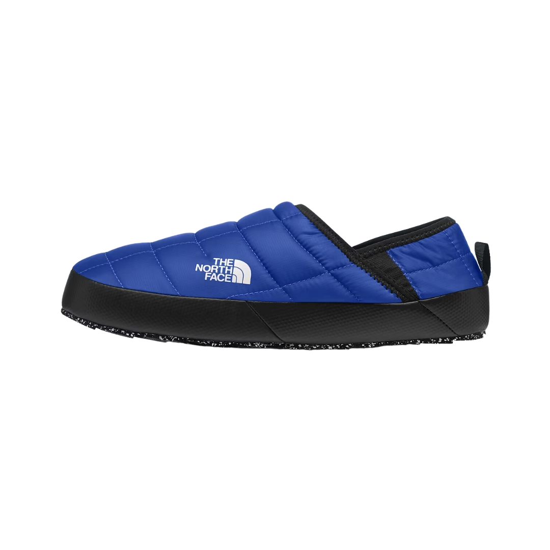 Chaussons bleus à enfiler avec semelle et bordure noires, ornés du logo The North Face en blanc. Le modèle est matelassé et doté d'une languette au talon.