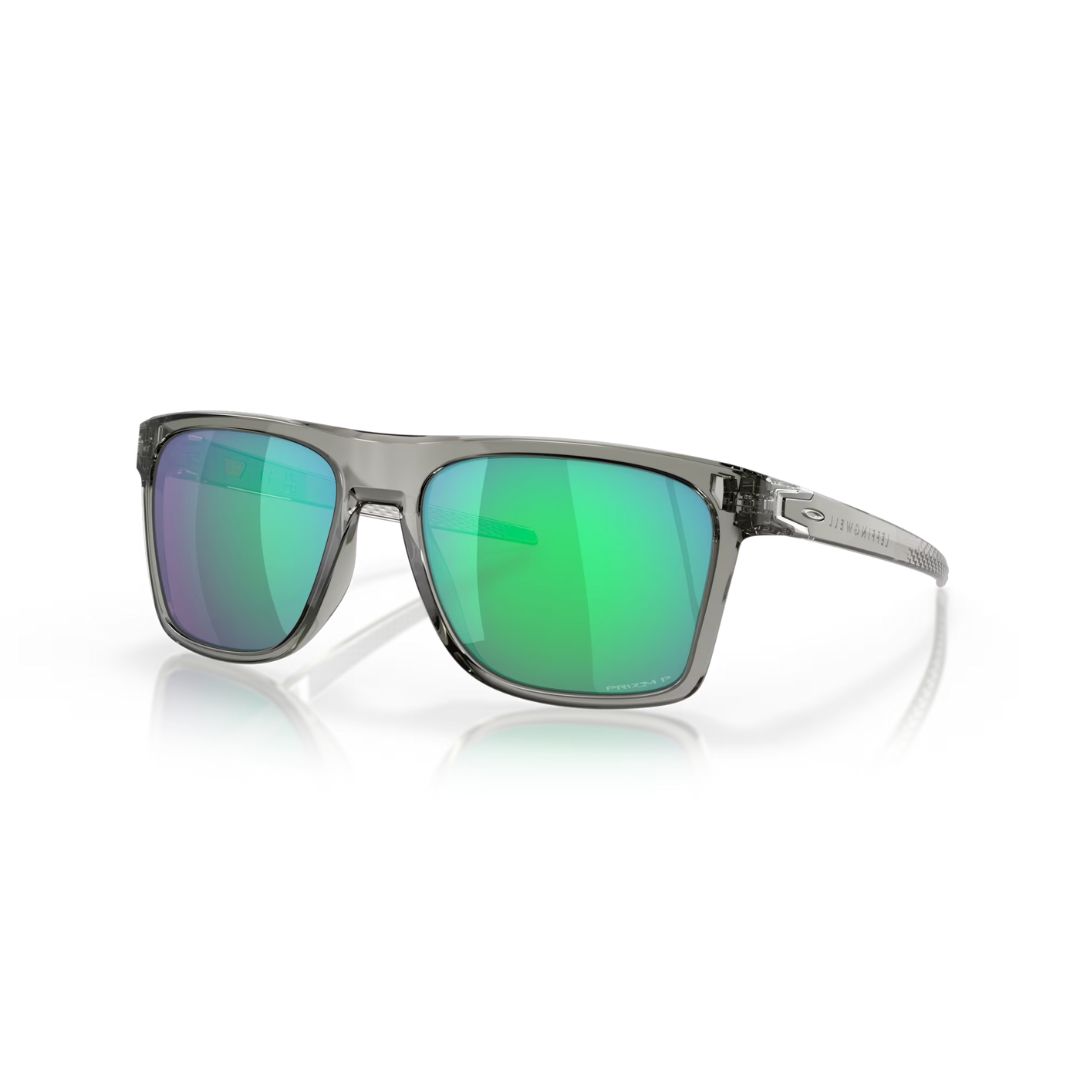 Photo de lunettes de soleil élégantes à monture transparente et verres verts réfléchissants. Les lunettes sont positionnées en biais, mettant en valeur leur design et leur style modernes, avec un reflet subtil sur la surface en dessous.