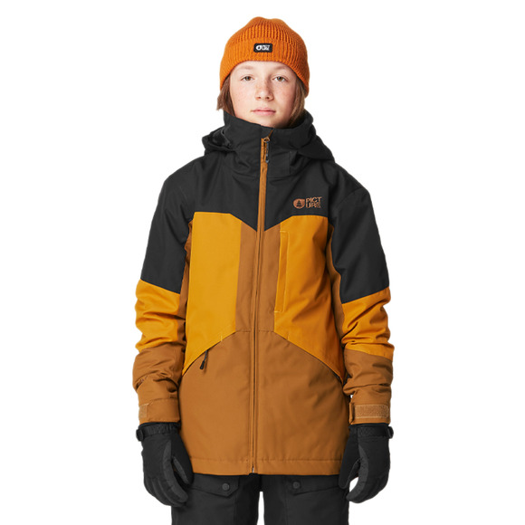 Personne portant un bonnet orange, une veste d'hiver noire et orange et des gants noirs, debout sur un fond blanc uni. Son expression est neutre et la veste porte un logo sur le devant et un design bicolore avec du noir sur les épaules et de l'orange sur le corps.